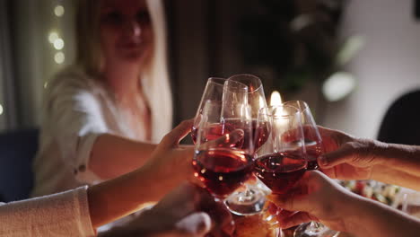 a group of friends clink glasses of wine over the festive table