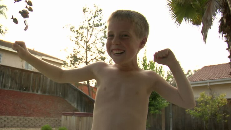 A boy poses like a bodybuilder