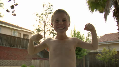 a boy poses like a bodybuilder