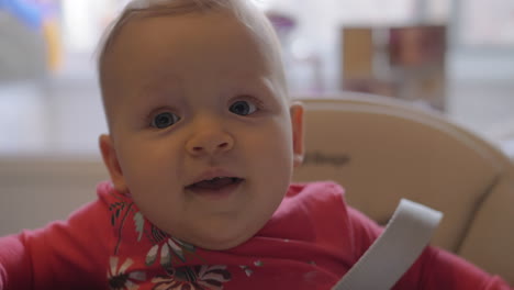 a closeup of a baby girl sitting in a high chair
