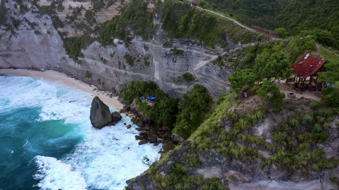 olas espumosas en la playa de diamantes con acantilado atuh en la isla de nusa penida, bali, indonesia