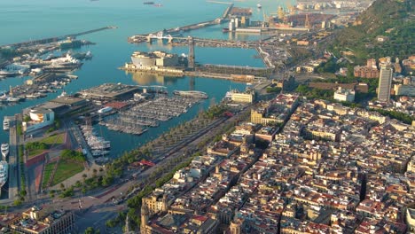 aerial view over square portal de la pau, and port vell marina and columbus monument at sunrise in barcelona, catalonia, spain