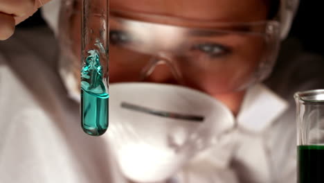 scientist swirling blue liquid in test tube