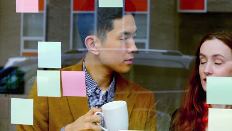 business executives discussing over sticky notes