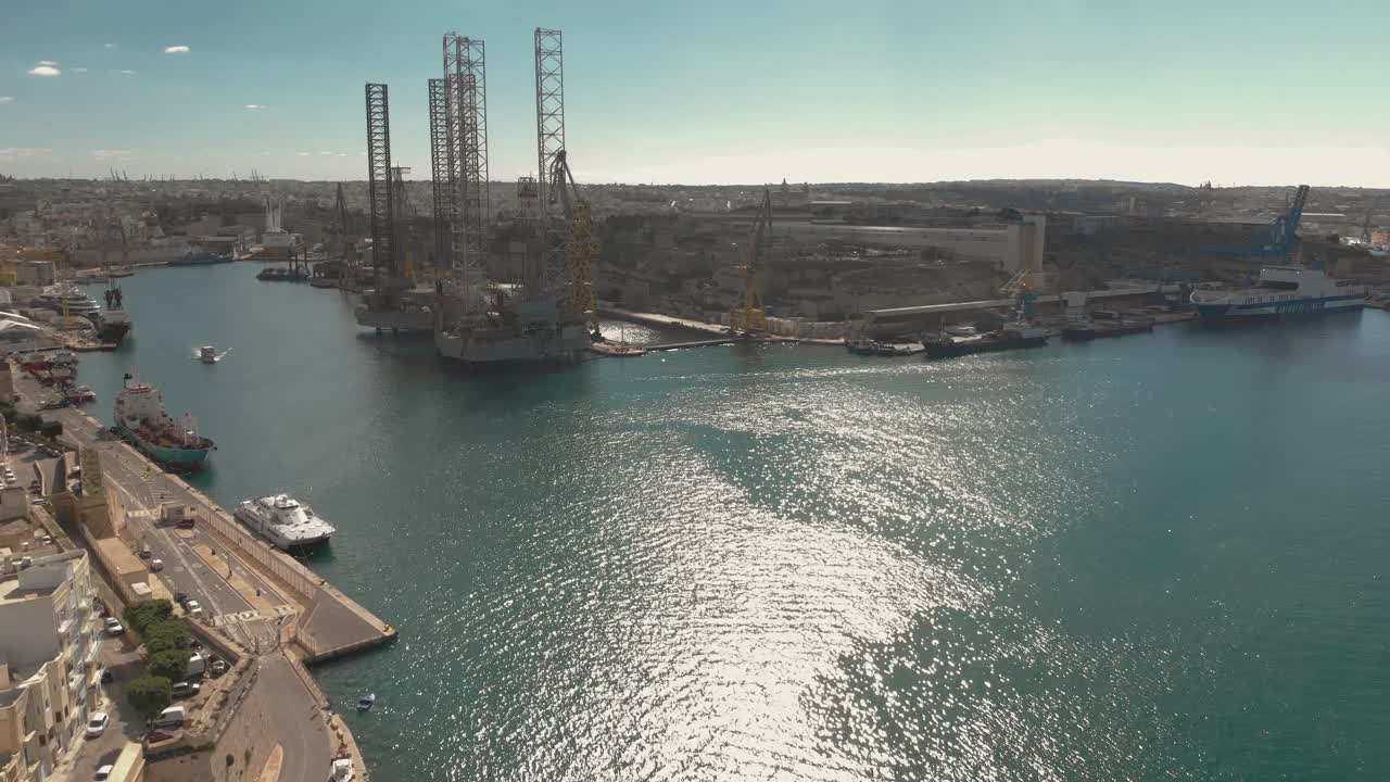 toma aérea hacia una ciudad vieja en una península al lado de un astillero