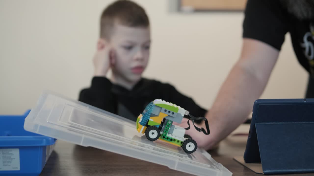 los niños participan en actividades de aprendizaje básico, montando kits de robótica con enfoque y trabajo en equipo en un entorno de aula