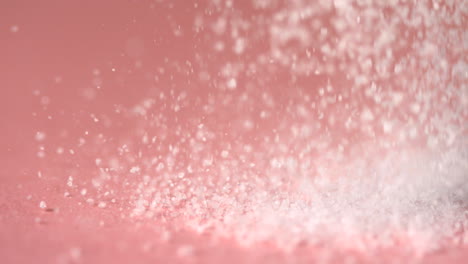 sugar falling onto pink surface