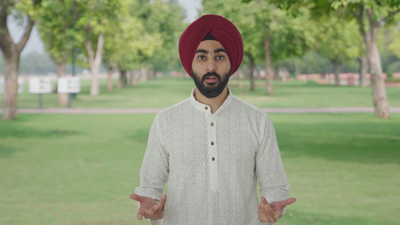 Sikh indiano confuso che si pone una domanda al parco