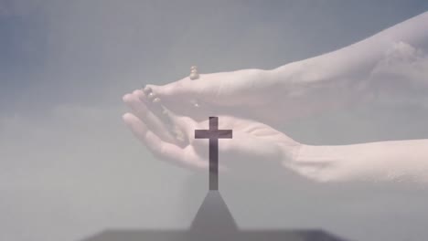 animation of caucasian woman praying with rosary over cross and clouds