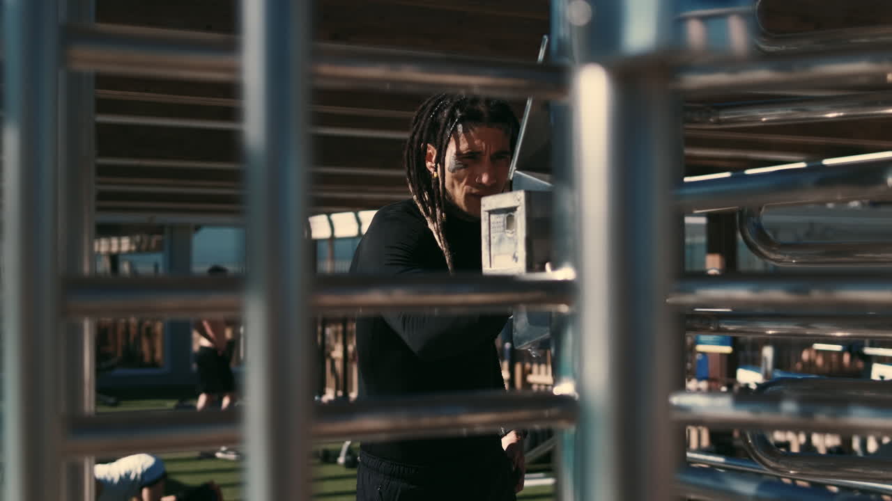 Focused Athlete with Dreadlocks Looking at Camera in Outdoor Gym