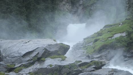 nubes de vapor blanco se elevan desde el fondo de la cascada y la roca escarpada