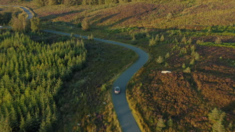 aerial footage, following a car on a mountain pass through a national park