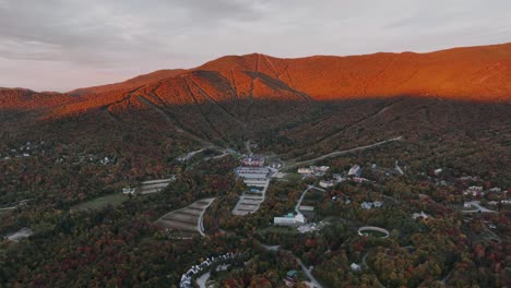 Vista-Aérea-De-La-Estación-De-Esquí-De-Montaña-De-Vermont-Y-Del-Hotel-Y-Residencias-Clay-Brook-Al-Atardecer-En-Nueva-Inglaterra,-EE.UU.