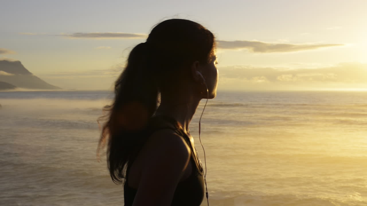 Mixed race woman runner running on beach road