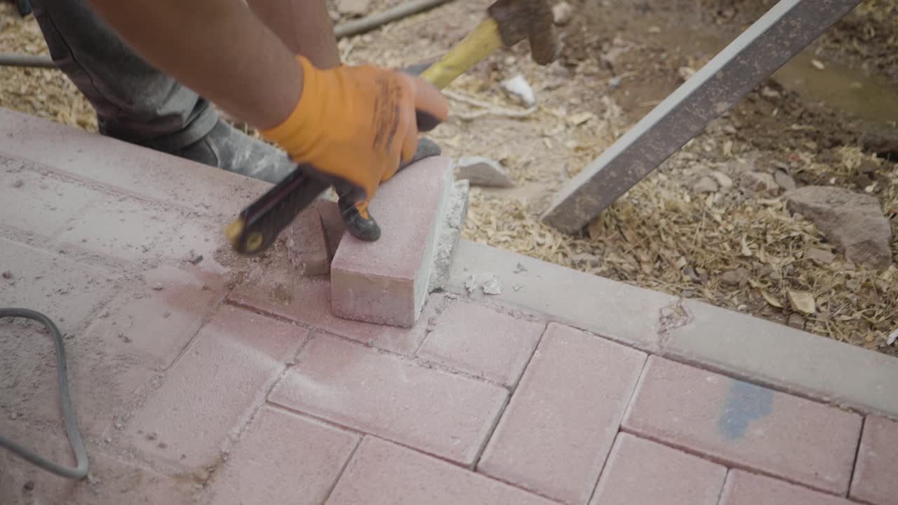 man using hammer to chip of old mortar