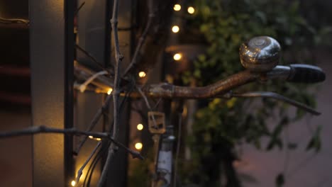 rusty old bicycle with christmas lights as decoration in front of restaurant