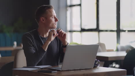 Thoughtful-serious-young-man-student-writer-sit-at-home-office-desk-with-laptop-thinking-of-inspiration-search-problem-solution-ideas-lost-in-thoughts-concept-dreaming-looking-away