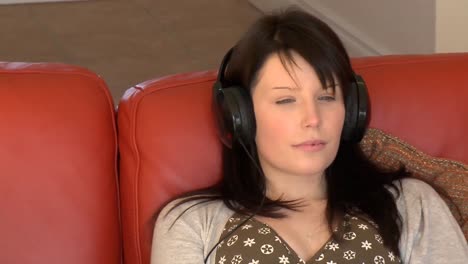 relaxed woman sitting on sofa and listening music