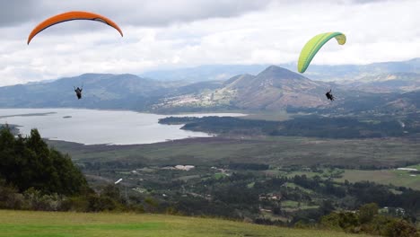 gente divirtiéndose haciendo parapente en una montaña con una hermosa vista
