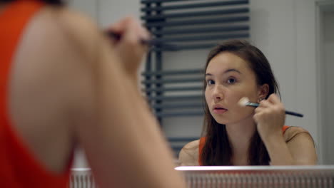 una adolescente aplicando maquillaje