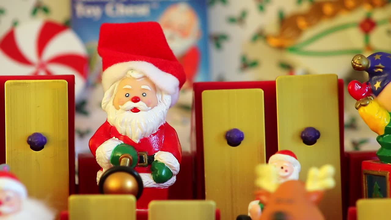 Dorking, England - August 07 2018: Christmas musical box showing Santa Claus and his helpers playing tunes on a toy xylophone. Close up of Santa Claus toy.