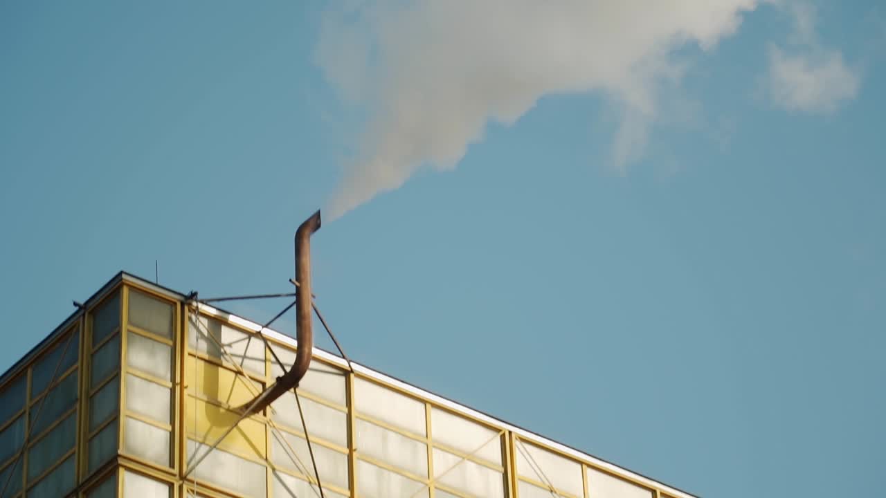 Close-up of factory chimney releasing white smoke