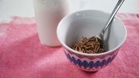 Cereal-bran-sticks-spilling-into-bowl-4k