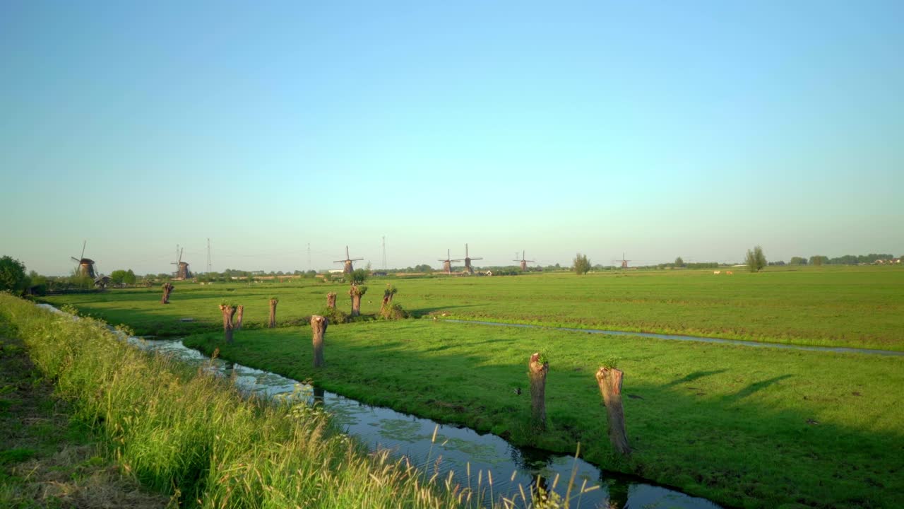 Dutch countryside polder pov Kinderdijk with mill green meadow ditch and polder