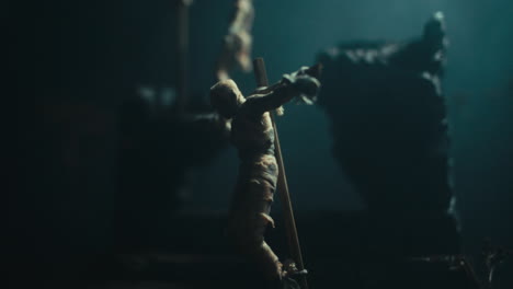 a miniature scene of the mummified dolls hanging on the gallows at night