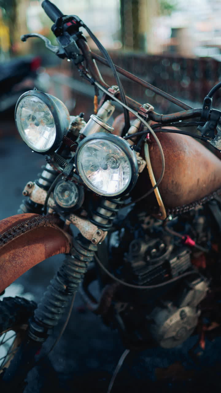 Close up of a vintage rusty motorcycle parked on a city street