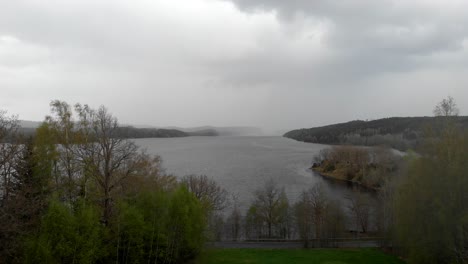 aerial shot of rain storm over a scenic lake, dramatic clouds in the sky