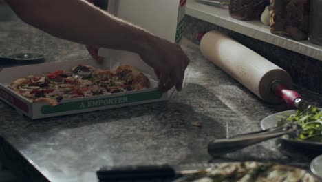 cocinero preparando pizza para la entrega en la cocina