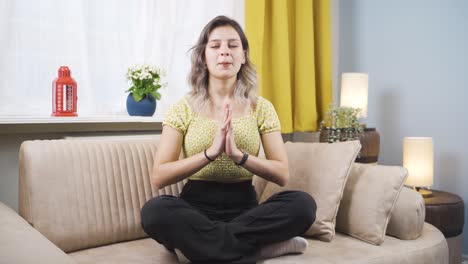 mujer joven en meditación frente a la ventana.