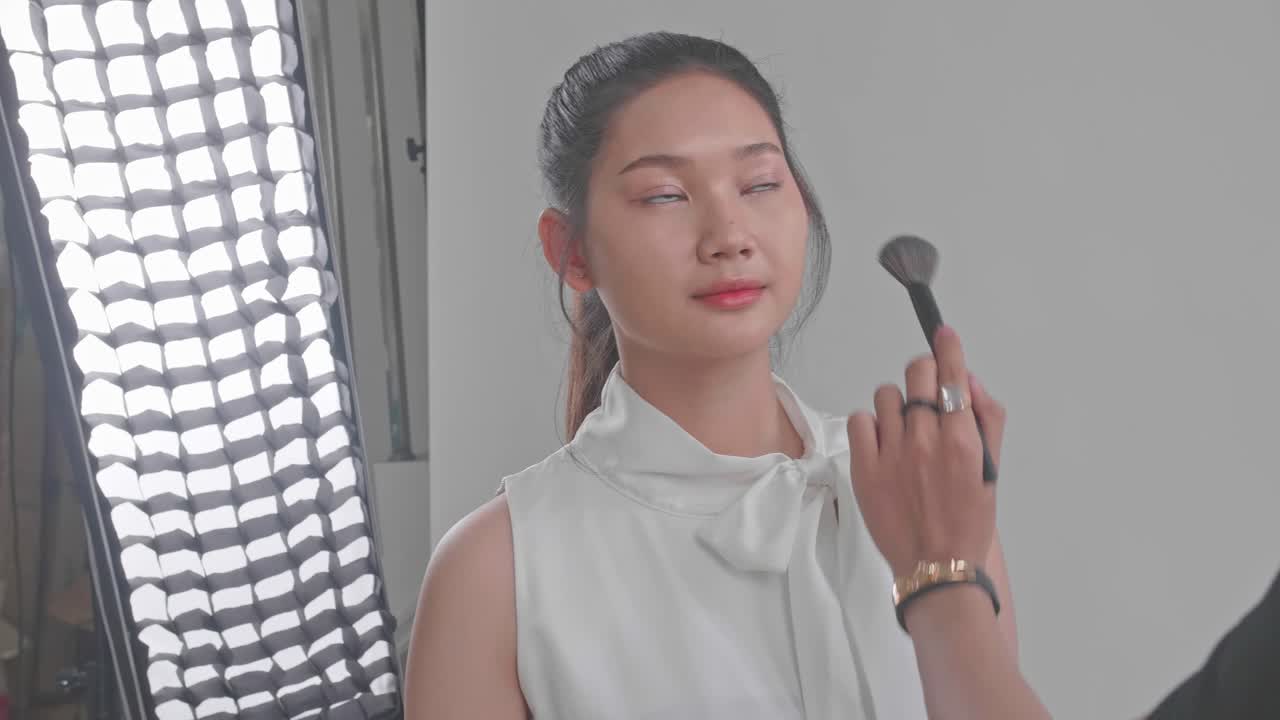 Makeup Artist Applying Blush to Model