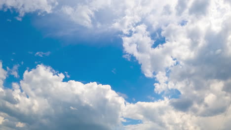 white cotton clouds soaring in the blue sky. little clouds gathering into a big cloudscape. timelapse.