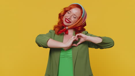 Smiling-ginger-girl-makes-heart-gesture-demonstrates-love-sign-expresses-good-feelings-and-sympathy