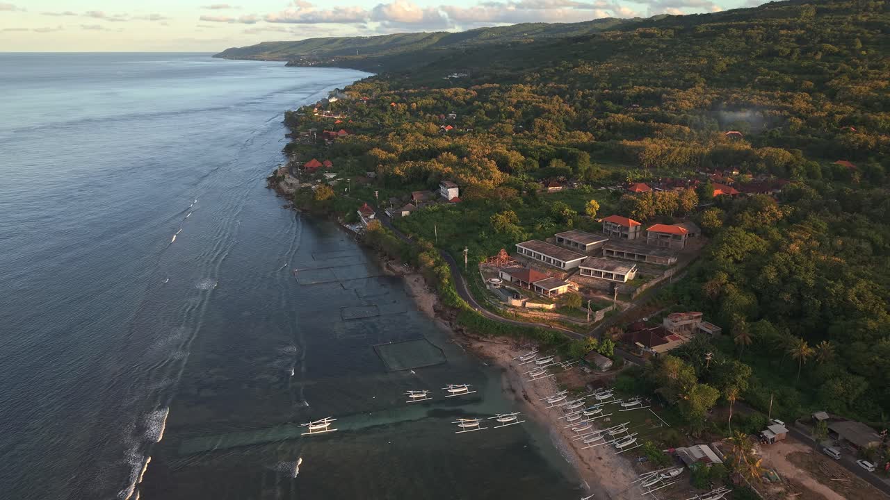 Traditional Indonesian fishing boats on beach at sunset on Nusa Penida island