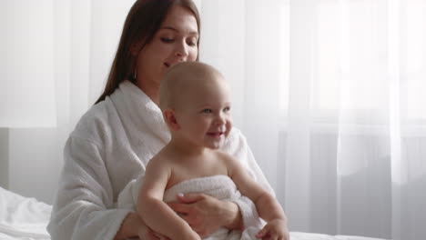 madre y bebé en bata de baño