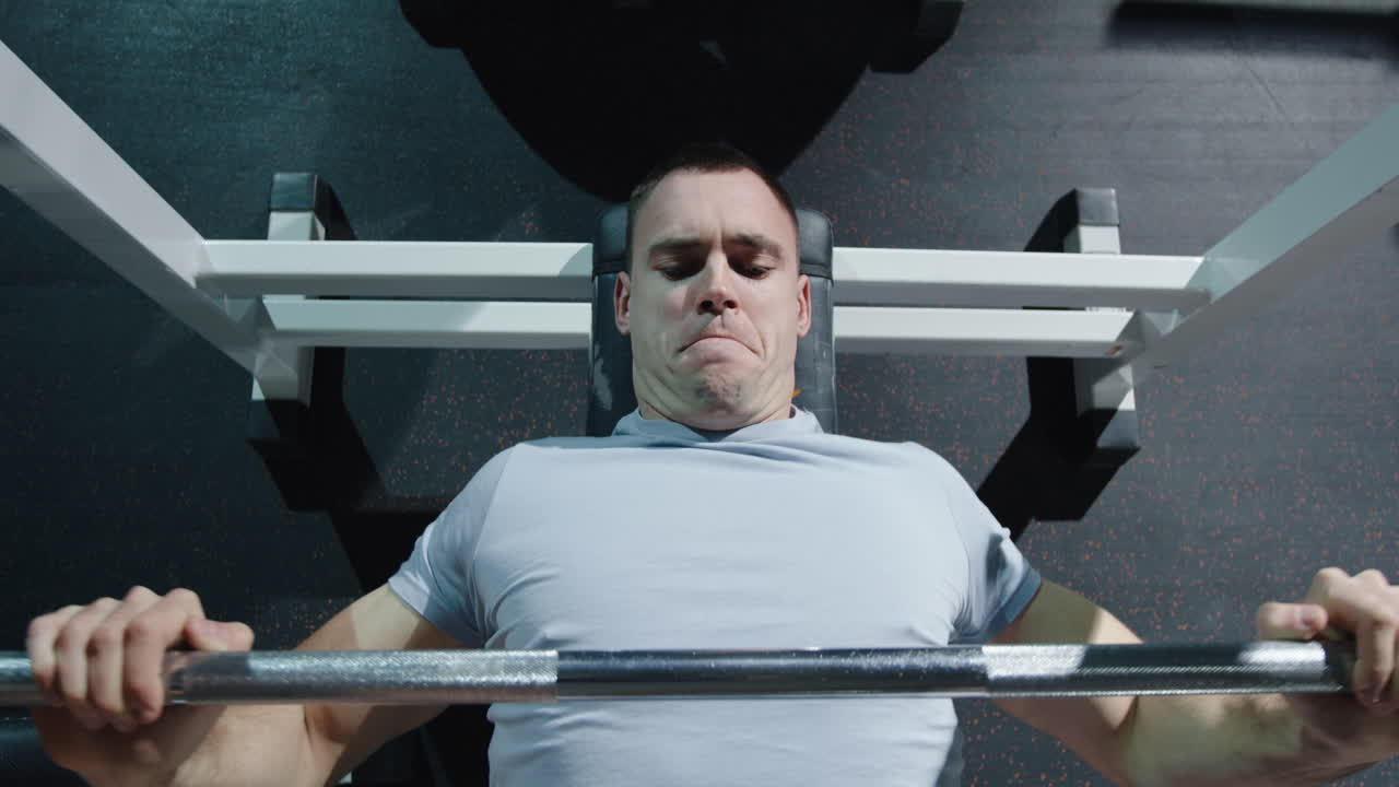 hombre realizando un ejercicio de press de banca en un gimnasio