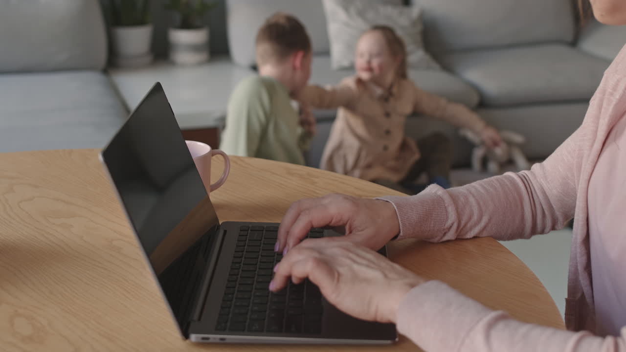 Mother working from home while children play