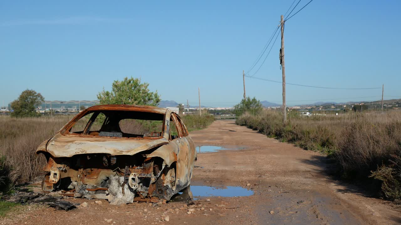un viejo camión abandonado y oxidado en un camino de tierra fuera de la ciudad y lejos de la carretera