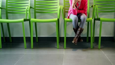 upset girl sitting on chair in hospital corridor