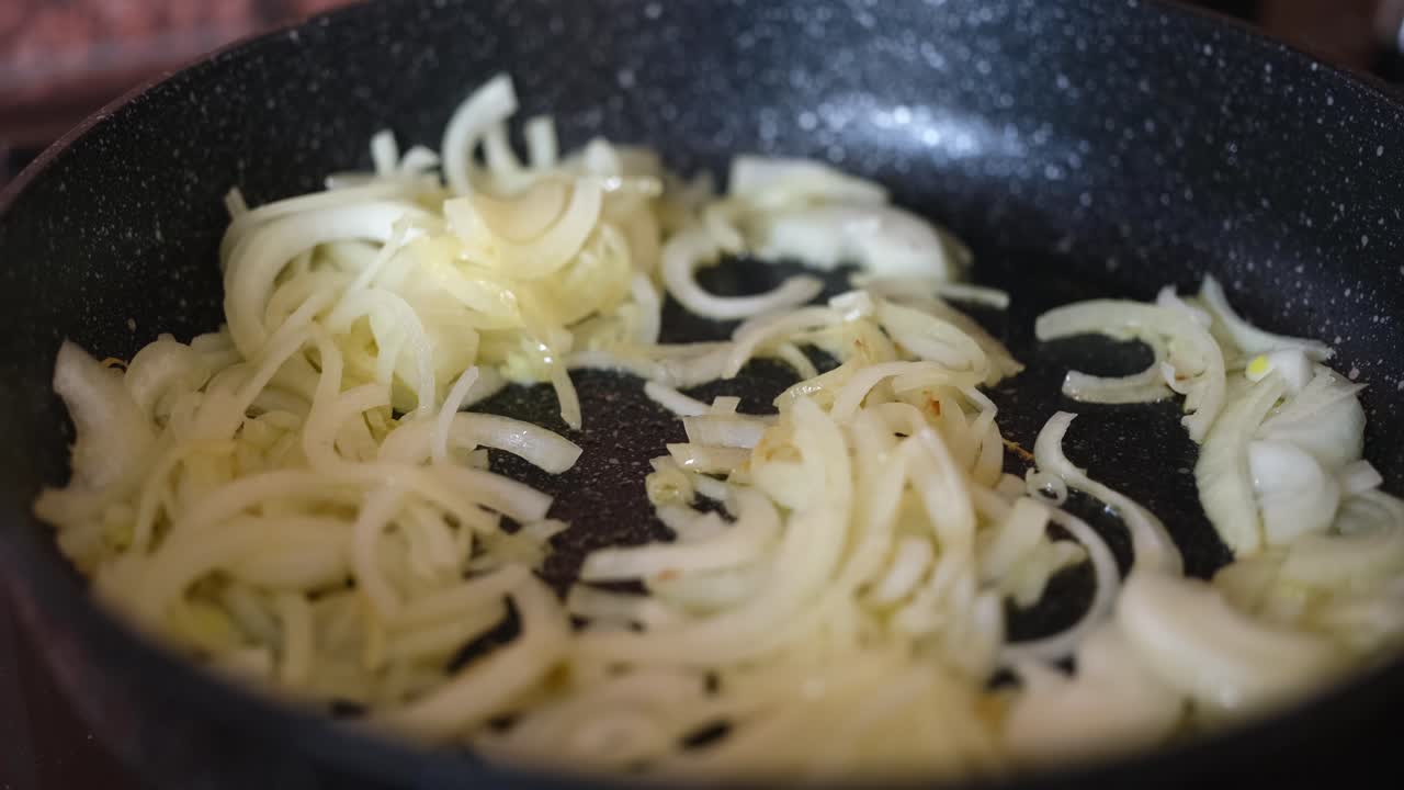 Close-up de cebola fritando na panela: calorias, benefícios e malefícios para a saúde da cebola frita