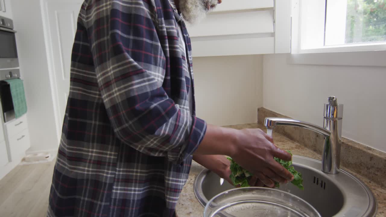 hombre mayor limpiando verduras en el fregadero en casa