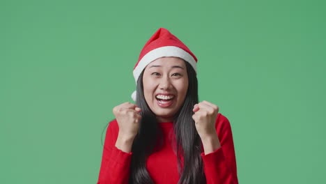 excited woman wearing santa hat