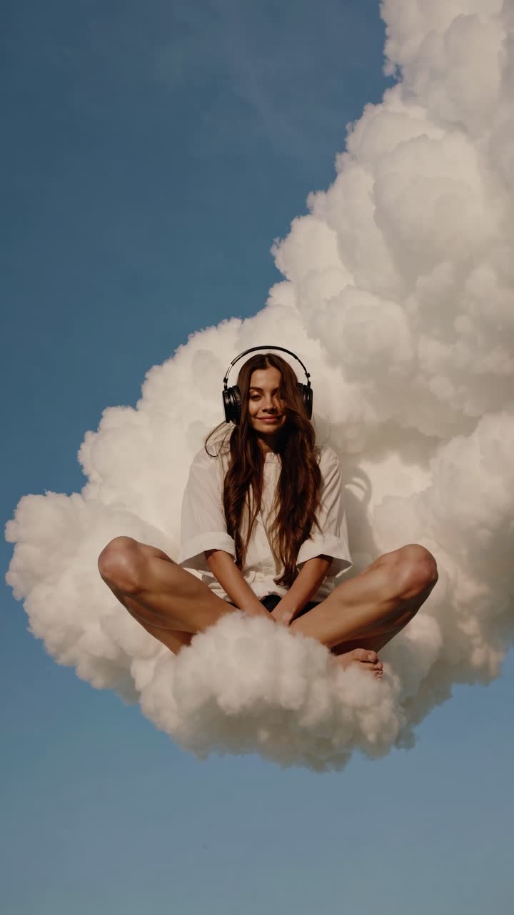 Aerial view of a woman with headphones sitting on a fluffy cloud against a blue sky