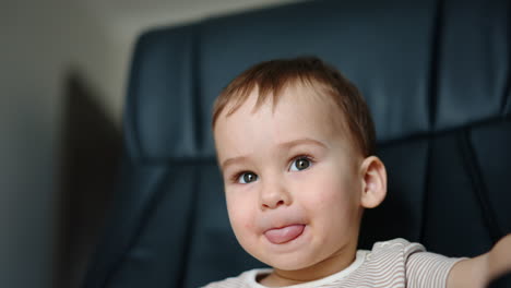 lovely caucasian boy smiling adorably to the camera. funny child shows the tongue to camera playfully. close up.