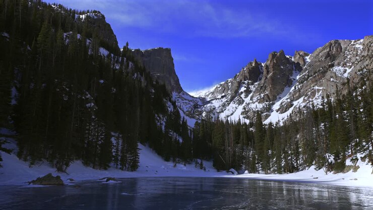 Inverno ghiacciato, Dream Lake, Parco Nazionale delle Montagne Rocciose (RMNP), Colorado. Venti forti che sollevano la neve. Hallett Peak, Montagne Flattop, Ghiacciaio Tyndall. Paesaggio alpino d'alta quota, Emerald Lake, sentiero di Bear Lake