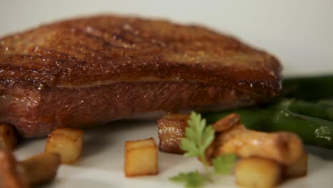 close-up of a juicy, perfectly seared steak with roasted vegetables on the side