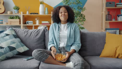 teenager enjoying chips on the sofa